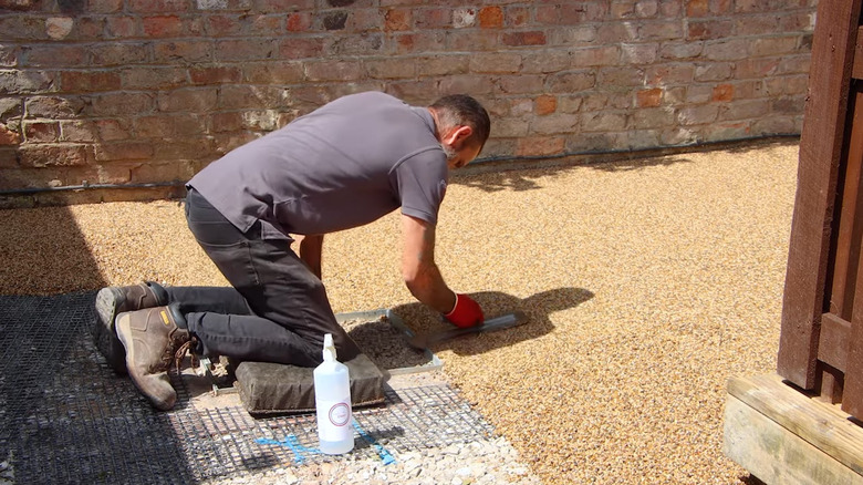 a man trowels a resin and aggregate mix smooth