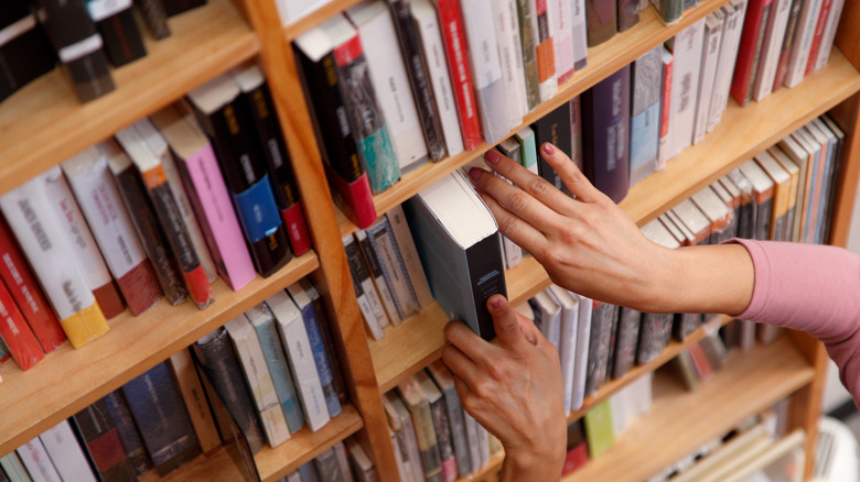 Woman in the bookstore selecting books.