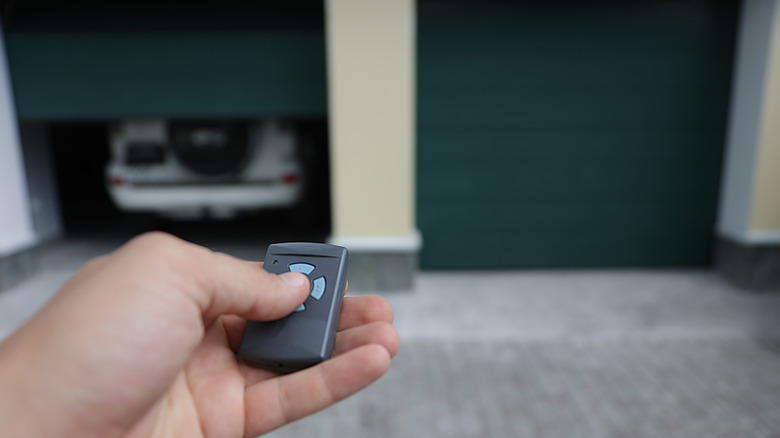 Person opening garage door with remote