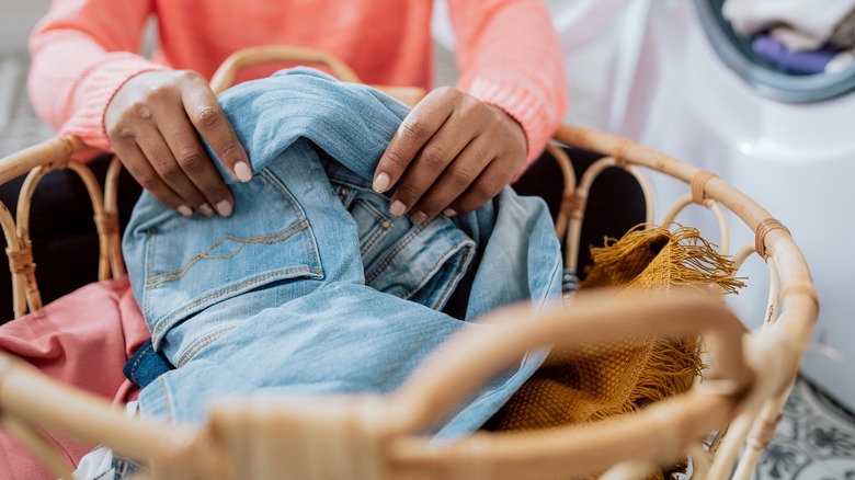 person adding clothes to basket