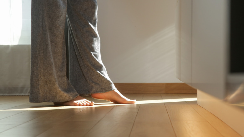 barefoot woman stepping on floor