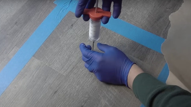Injecting syringe to level flooring