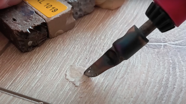 Soldering iron patching floor hole
