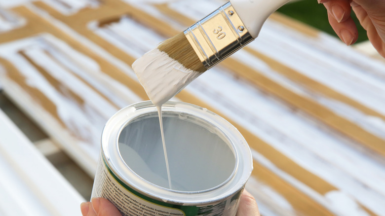Person uses white paint to refresh their wood closet door.