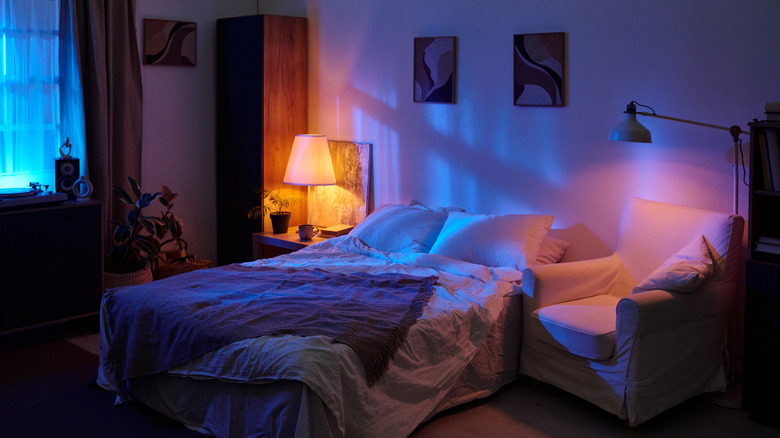 Bedroom decorated with nightstand, chair, and colorful lighting