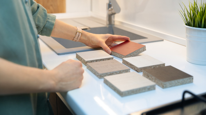 Woman's hands arranging countertop samples in the kitchen