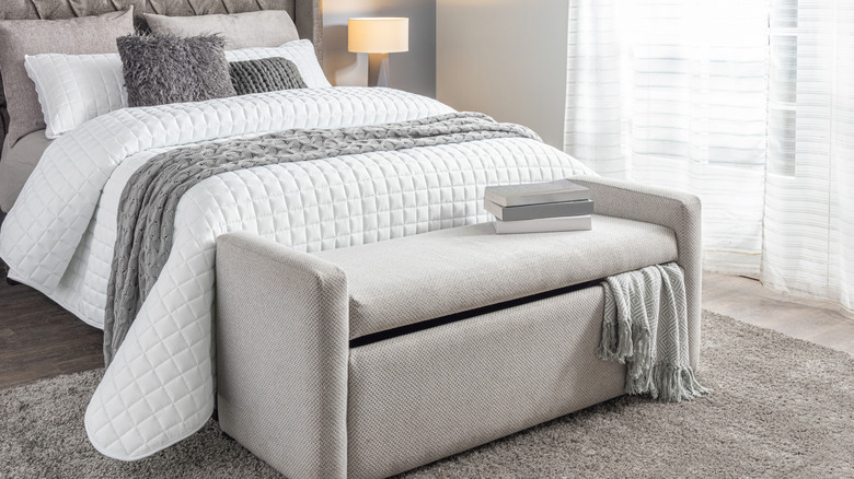 Gray bedroom with storage bench at foot of bed