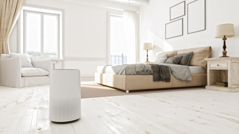 An air purifier inside a bedroom with white walls