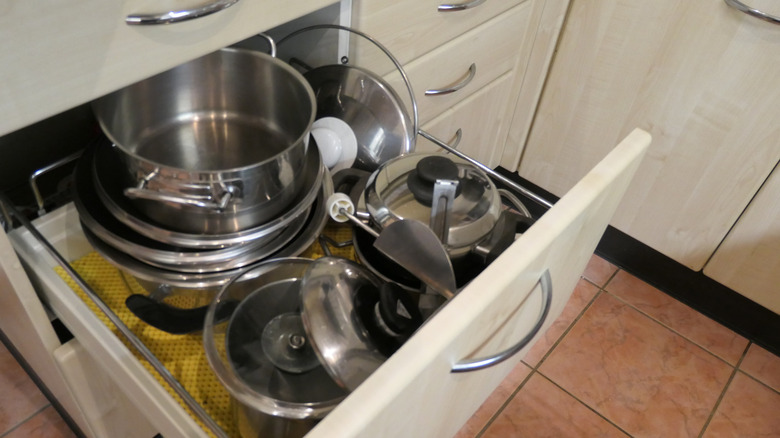 A drawer filled with pots and pans