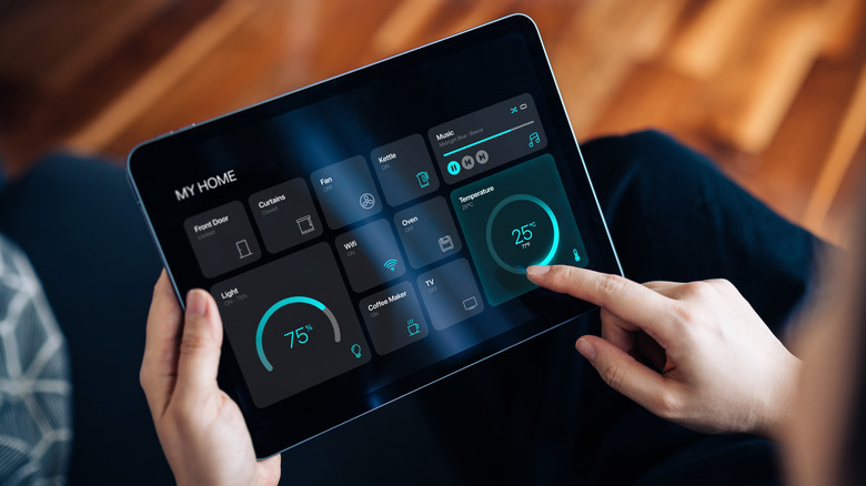 A person using a tablet with options to control items in the home