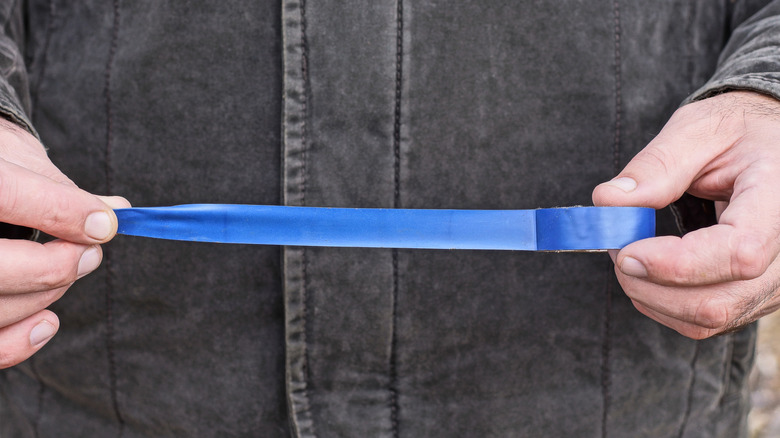 Man unrolling tape
