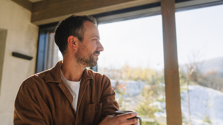 Man looking out sliding glass doors