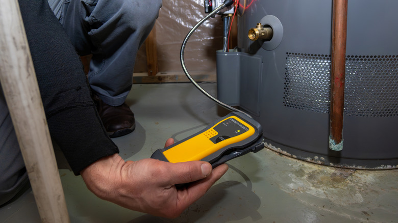 A worker testing a gas furnace for carbon monoxide