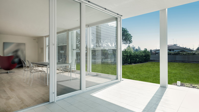 A home with transparent floor-to-ceiling sliding glass doors as backyard access.