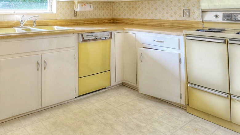 Dated kitchen with a yellow dishwasher and stove