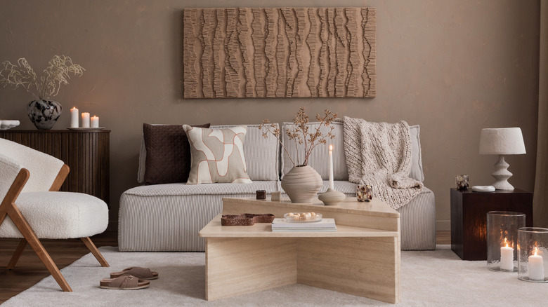 A Japondi style living room features contemporary seating and a brindle colored wall