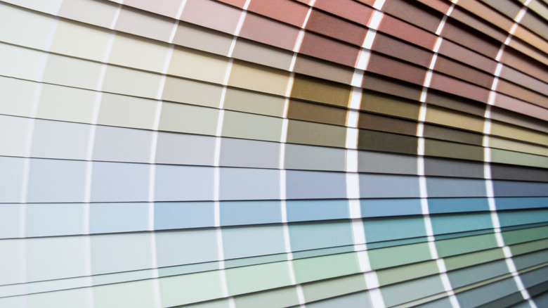 A fanned-out wheel of cool-toned paint swatches, including shades of green