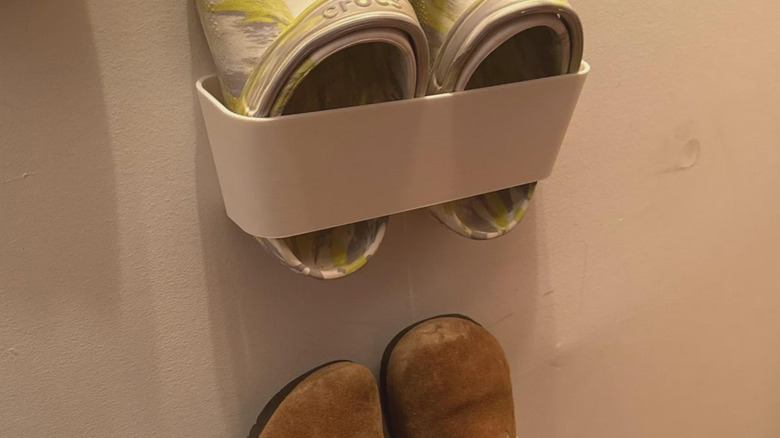 Pairs of shoes stored on the wall in individual brackets.