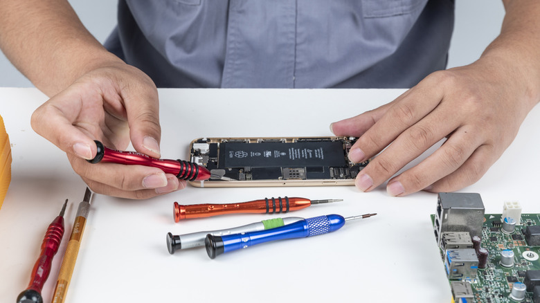 A set of small precision screwdrivers helping repair a phone