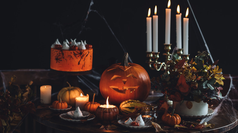 Halloween party set up with gourd, desserts, pumpkin candles, candelabra and more