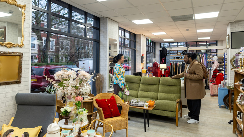 A couple shopping in the furniture section of a thrift store