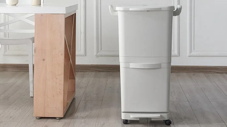 white wheeled trash can next to a kitchen table