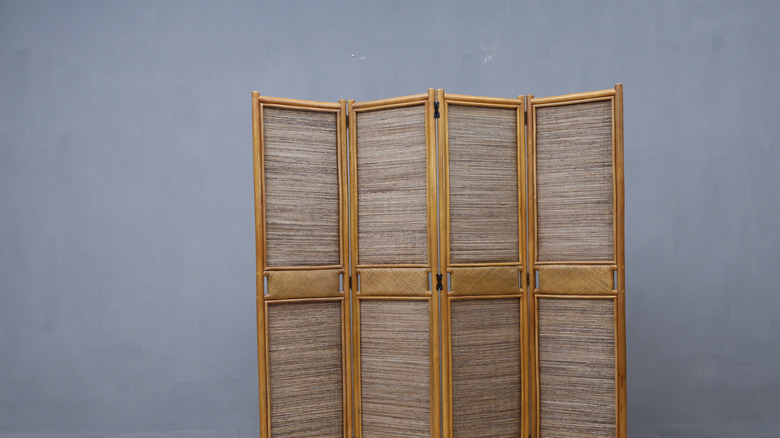 gray and wood folding screen against gray wall