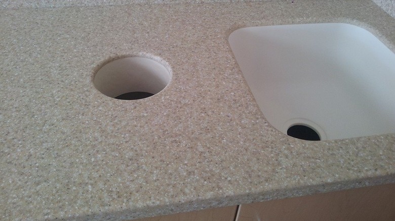 kitchen countertop with sink and trash chute