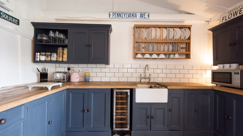 kitchen with blue cabinets, subway tile and open cabinets
