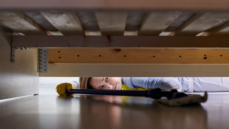 Woman cleaning under furniture