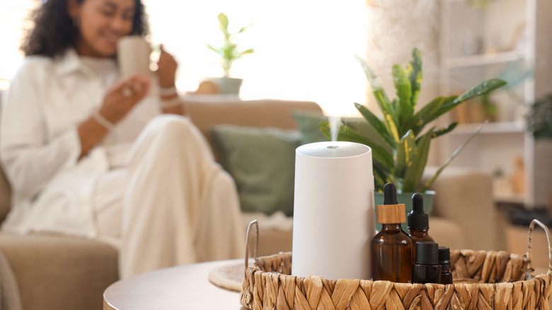Woman smiling in the background with aroma therapy diffuser in the foreground