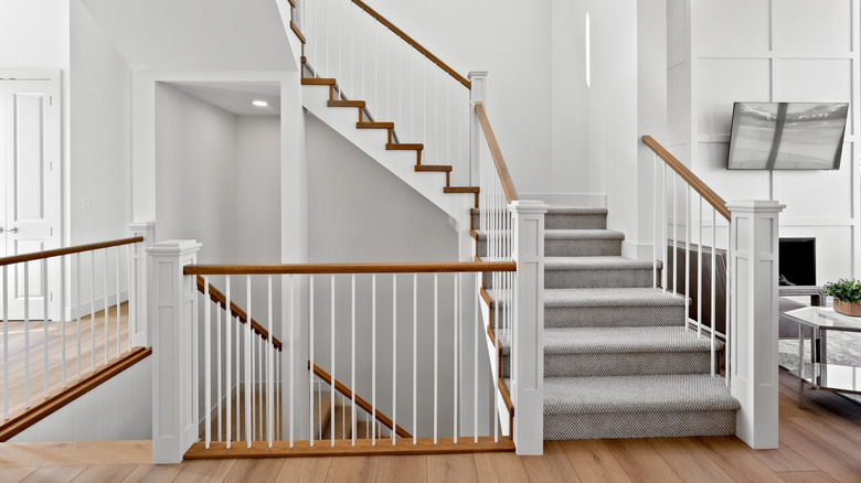 Wood staircase on the mid level of a home that continues on multiple levels