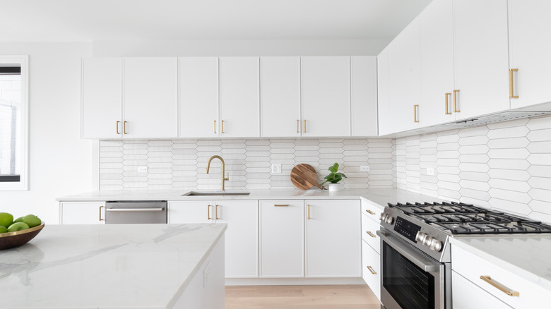 modern kitchen with white cabinets, walls, and countertops