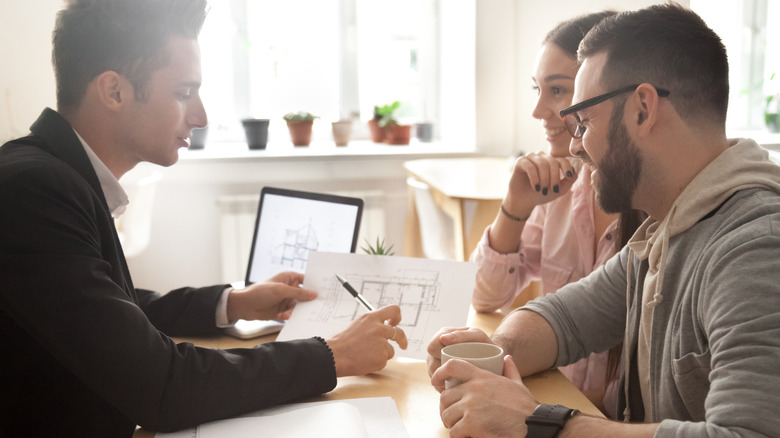 Architect showing their plans to a smiling couple