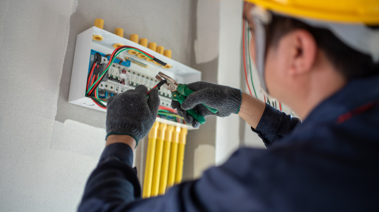 An electrician working on the wiring of a house