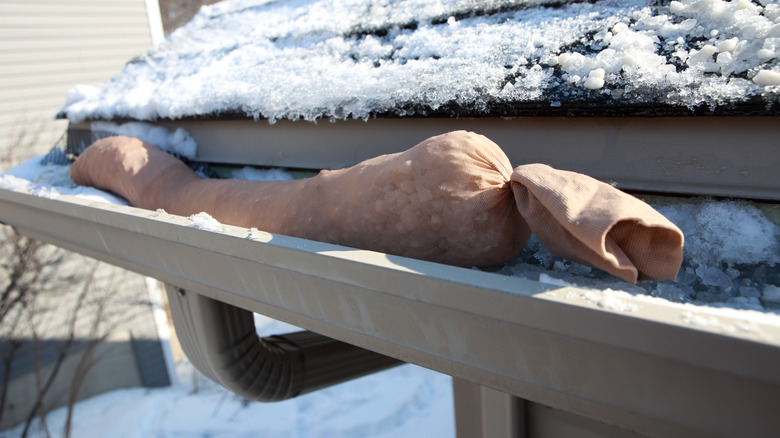 Stocking filled with ice melt in gutter