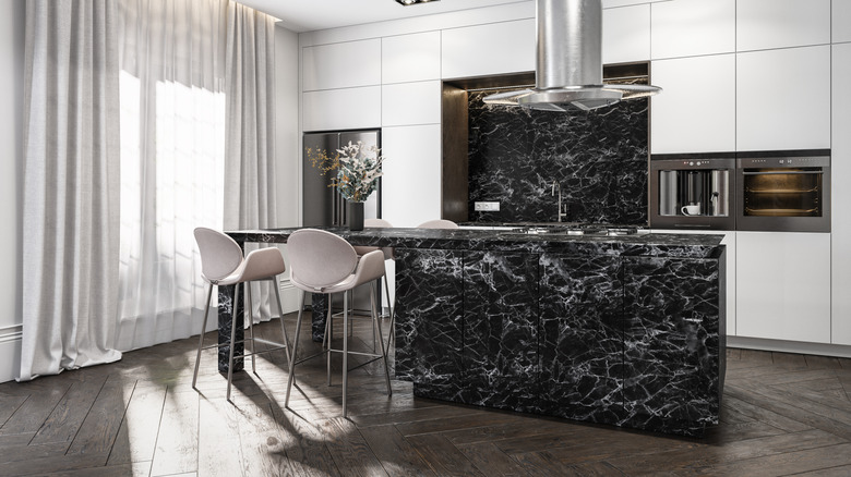 Stylish kitchen designed with dark wood elements and Calacatta Viola marble on the island waterfall, countertops and backsplash