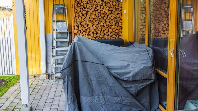 Outdoor furniture that has been covered and pulled under the porch roof
