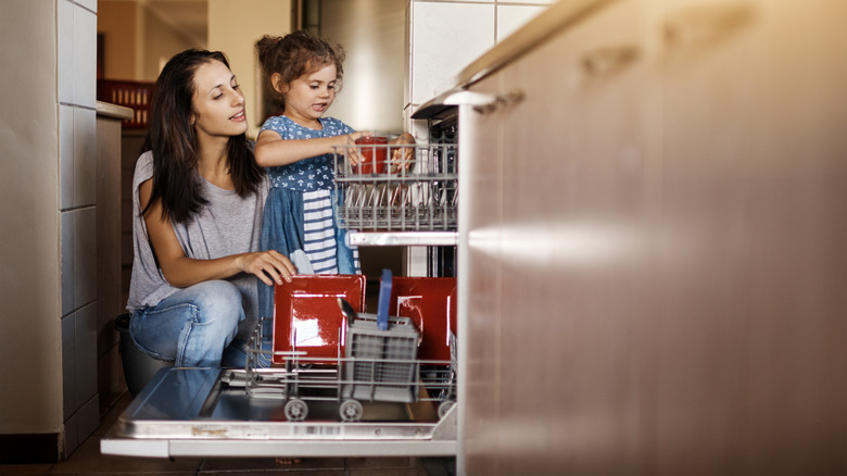 mom and kid loading dishwasher