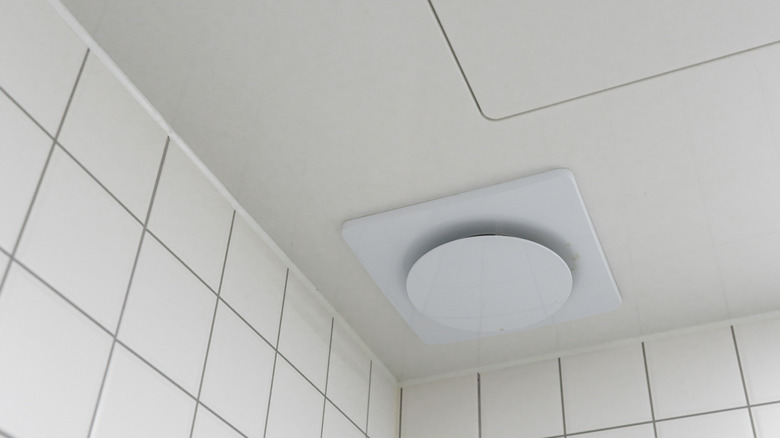 A boring bathroom ceiling in all white with white tiled walls