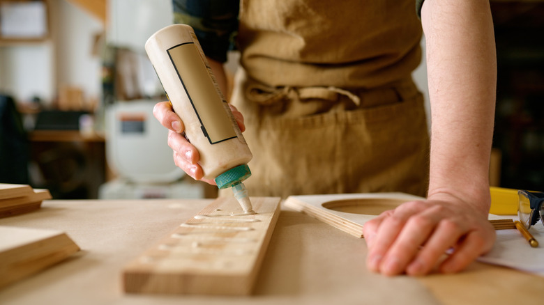 Person applying wood glue to a board