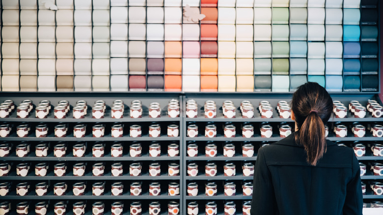 A shopper browsing paint swatches in a store