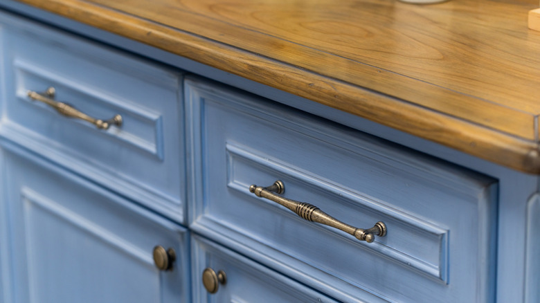 aged brass cabinet pulls and knobs on blue cabainets