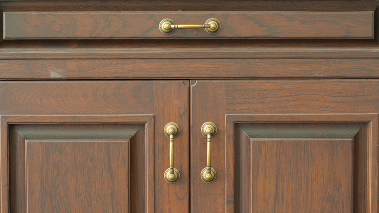 close up of wooden cabinet with brass hardware