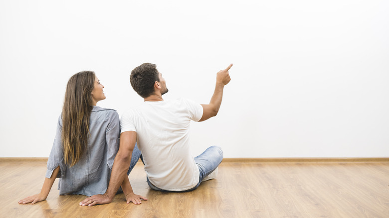 Couple looking at an empty wall in their home