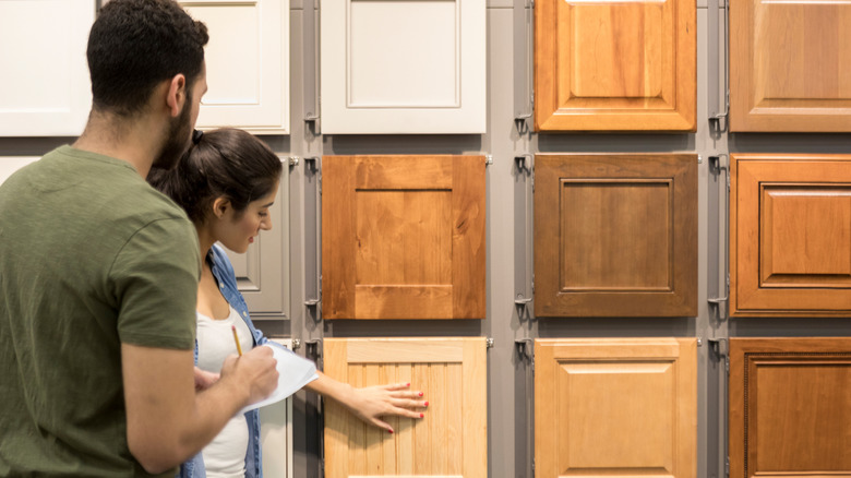 Couple browsing cabinet door samples at store