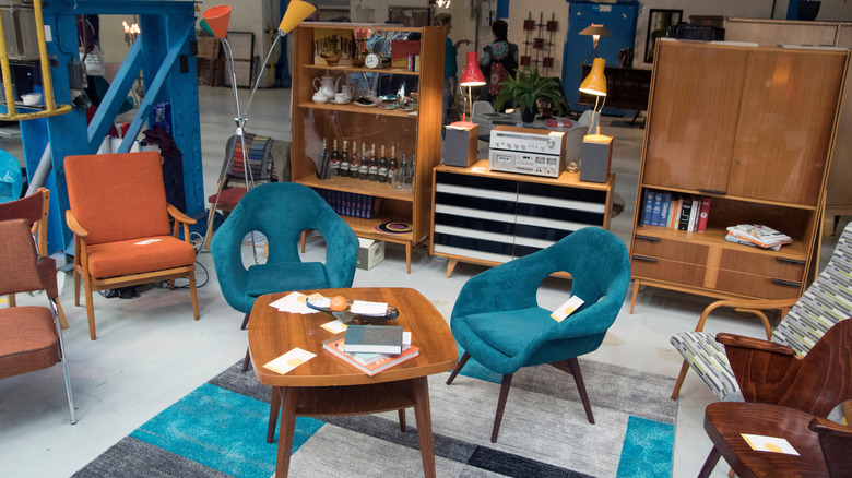 Mid-century modern decor, including furniture and lamps, at the thrift store