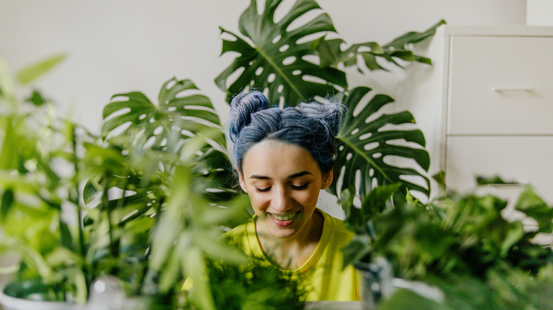Young woman in her home taking care of her plants