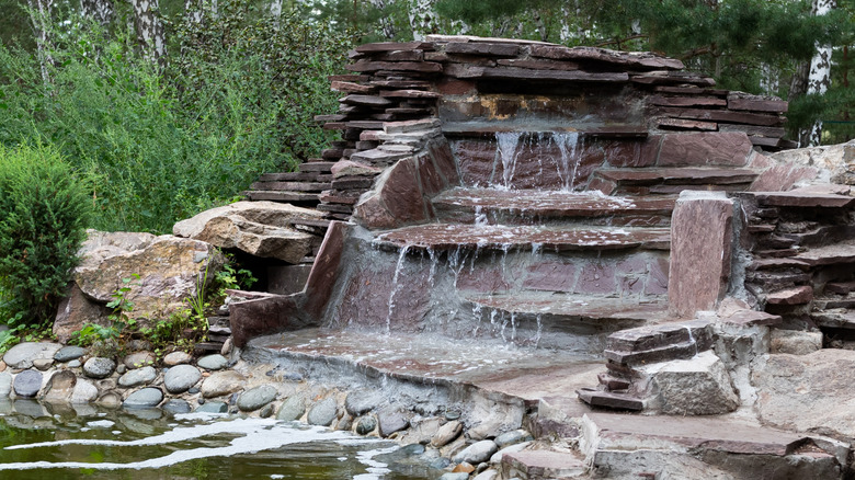 flagstone garden waterfall surrounded by greenery