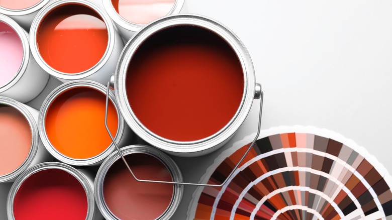 Different shades of red cans of paint